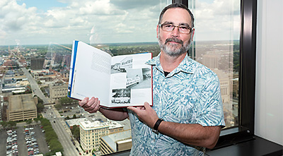 Joe Pearson of OneAmerica holds a book that featured a photo of his father Dr. John Pearson.