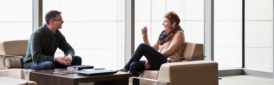 Man and woman talking while sitting in separate chairs